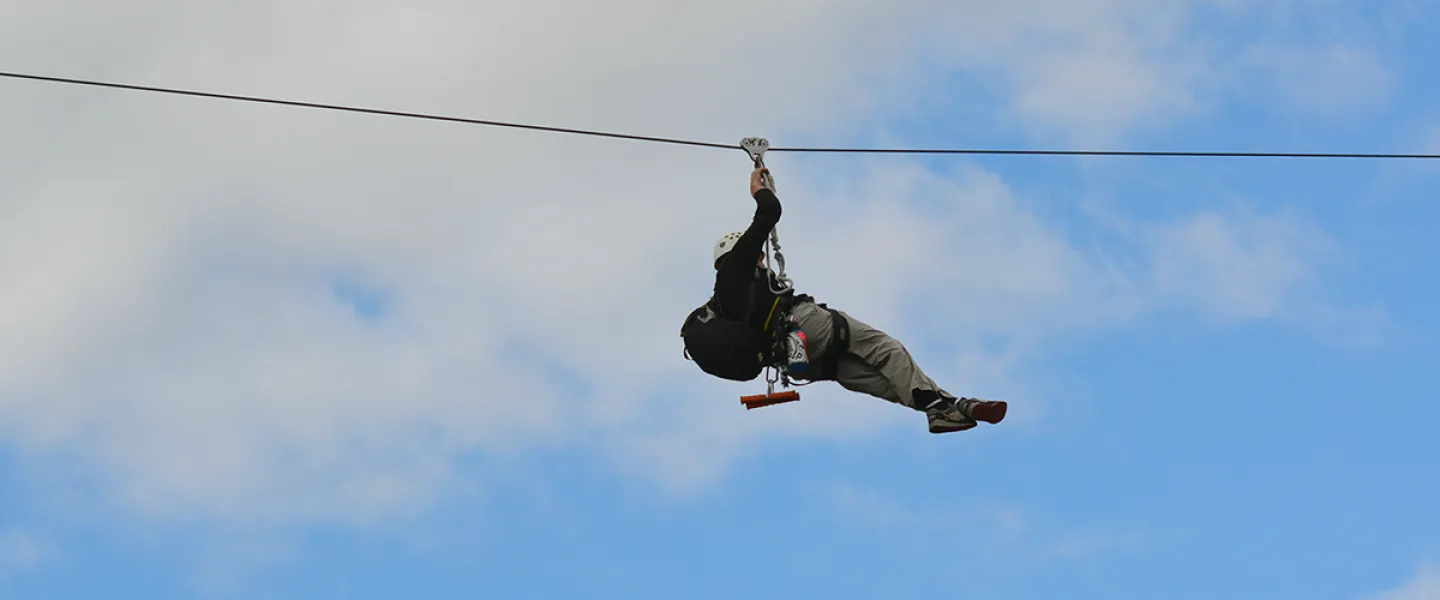 A man on the zipline at camp
